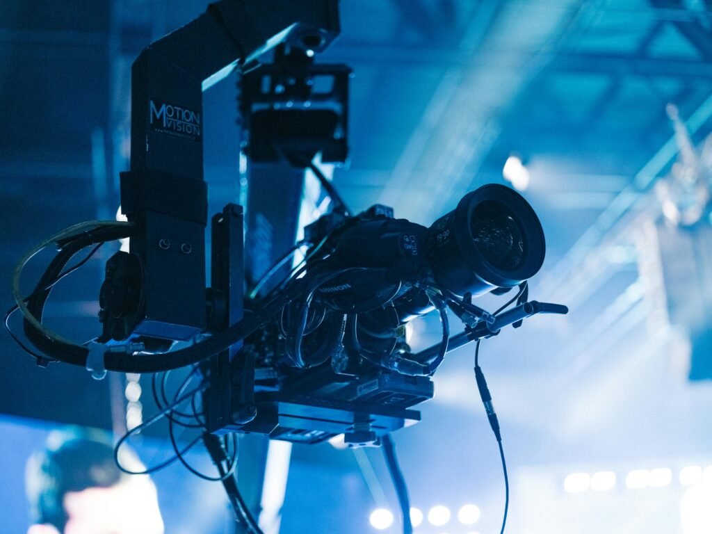 Close-up of a professional video camera mounted on a crane arm during a studio filming session.