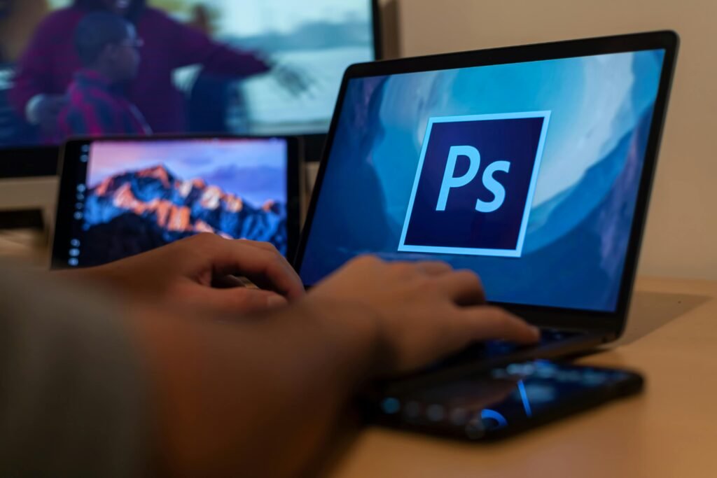 Adobe Photoshop – Image Editing & Creative Design Hands working with Photoshop on a laptop, showcasing digital photo editing from home.